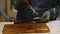 Close-up of female hands is applying of protective varnish on wood plank.