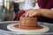 close-up female hands of an artisan potter twist ceramic utensils on a potter\'s wheel