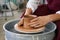close-up female hands of an artisan potter twist ceramic utensils on a potter\'s wheel