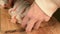 Close-up of female hands are cutting with a knife a large salmon on a wooden table of home cooking