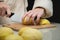 Close-up of female hands cutting peeled potatoes on a wooden cutting board. Home cooking potatoes