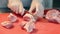 Close-up of female hands cutting pieces of meat. Pork slicing. Female hands in gloves cut pork into pieces with a