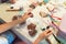 Close-up of female hands decorating gingerbread cookies