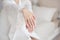 Close-up female hands in focus with blurred slim waist body on background.