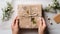 Close up female hands hold a beautiful gift box. Craft paper and gift decoration with natural flowers and dried flowers. Eco