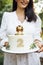 Close up of female hands hold a birthday baby cake. Delicious sweet pie with cute lion cub, number two and leaves