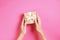 Close up of female hands holding birthday gift in vintage craft paper wrapping. Femenine composition with present in woman`s arms