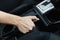 Close up of female hands holding a handbrake lever to keep the vehicle stationary. The girl puts the car in the Parking lot with t