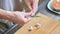 Close-up of female hands at home kitchen clean garlic from the peel. Shallow depth of field