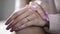 Close-up of female hands lying on knees with gold engagement ring, jewelry