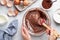 Close up of female hands mixing ingredients in bowl. Baking chocolate cake