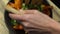 Close up of female hands mixing salad bowl contents. High quality