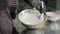 Close-up of female hands mixing sweet pastry topping in metal bowl indoors. Unrecognizable Caucasian young slim woman