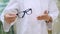 Close-up, female hands of an ophthalmologist in white form, keep a frame from glasses, spectacles. Ophthalmologist