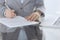 Close-up of female hands with pen over document, business concept. Lawyer or business woman at work in office