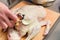 Close-up of female hands preparing duck or goose for baking. White carrot dressing with mayonnaise. Christmas dish duck