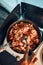 Close up of female hands putting dish with tomato sauce. Woman cooking meal on electric stove on camping during summer vacations