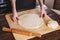 Close-up of female hands rolling out a ball of pizza dough cooking at home