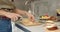 Close up of female hands slicing cheese for sandwiches in the kitchen