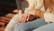 Close up of female hands of two friends girls sitting outdoors. Caring young woman holding hand supporting her friend