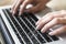 Close-up of female hands typing text on the keyboard of laptop or computer. Manager.