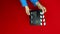 Close up female hold in hand classic director clear empty black film making clapperboard isolated on red background