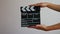 Close up female hold in hand wooden director clear empty black film making clapperboard isolated on gray background