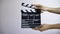 Close up female hold in hand wooden director clear empty black film making clapperboard isolated on gray background