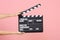 Close up female holding in hand classic director clear empty black film making clapperboard isolated on trending pastel