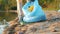 Close-up of female legs and hands collecting garbage on the lake shore in summer