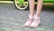 Close-up. female legs in stylish pink sneakers. girl walking on the street with pavement. Natural sunny daylight