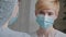 Close-up female masked face, portrait caucasian sick woman patient wears medical protective mask speaks to