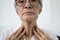Close up of female neck,asian senior woman thyroid gland control,old elderly was touching the neck,checking thyroid gland with her