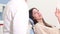 Close up of female patient talking with dentist while sitting in dental chair