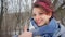 Close-up female portrait of glam rock style look of a beautiful girl with dark pink hair and mohawk wearing blue scarf