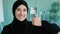 Close-up female portrait in office Muslim happy satisfied contented Islamic Arabian woman wearing black hijab looking at