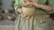 Close up female potter's hands sculpting a clay pot with her hands. A ceramist works with raw earthenware to create