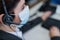 Close-up of a female receptionist wearing a facial mask talking on a headset while sitting at a work desk in the office