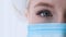 Close up of female surgeon with protective mask and white cap. Eye of a doctor