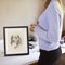 Close Up Of Female Teenage Artist Framing Charcoal Drawing Of Dog In Studio