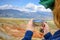 Close-up of female tourist shoots amazing natural phenomenon on her smartphone. Martian landscapes in the Altai mountains. Travel