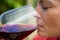 Close-up of female vintner tasting glass of wine