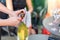 Close-up female waiter opening bottle of white champagne or prosecco at outdoor party on bright summer day. Girls hen-party