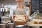 Close Up Of Female Worker in Cafe Serving Meal In Sustainable Recyclable Packaging With Wooden Fork