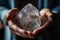 Close up of feminine hands holding beautiful quartz crystal for meditation, natural colors, view from the top