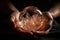 Close up of feminine hands holding beautiful round crystal for meditation, natural brown color, view from the top