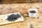 Close-up fermented Ivan-tea on wooden board. Dry herbal natural tea. White cup with Ivan-tea.