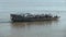 Close-up on a ferry boat full of people on bicycles and motorbikes crossing the river