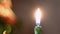 Close-up of festive candle on background of blurred lights. Concept. Clear focus on candle holder burning on background