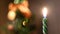 Close-up of festive candle on background of blurred lights. Concept. Clear focus on candle holder burning on background